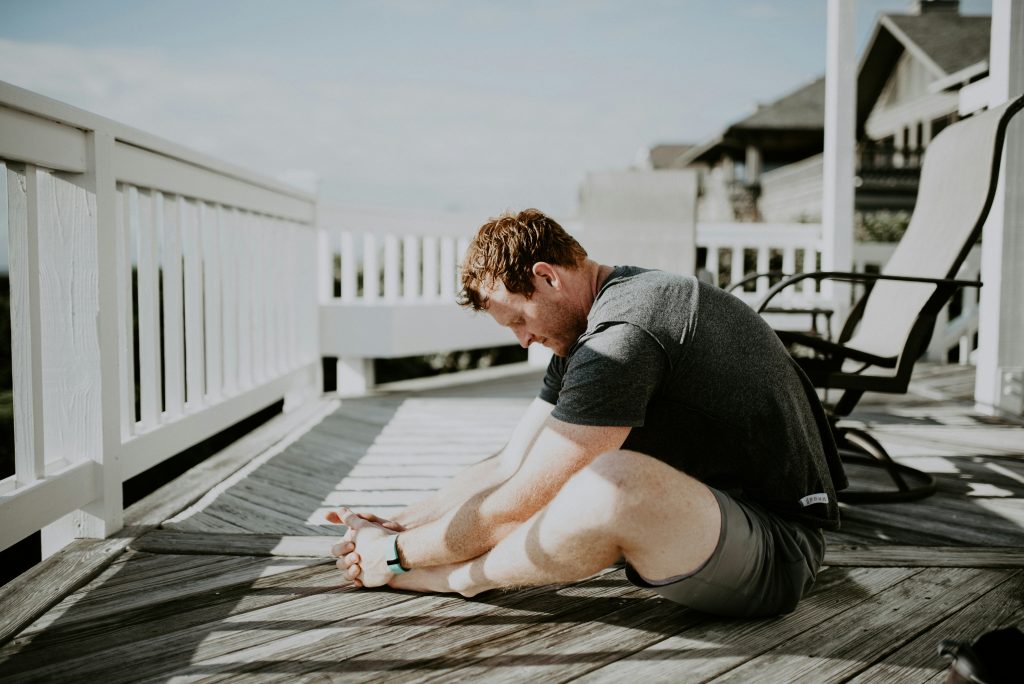 Man practicing yoga on porch.