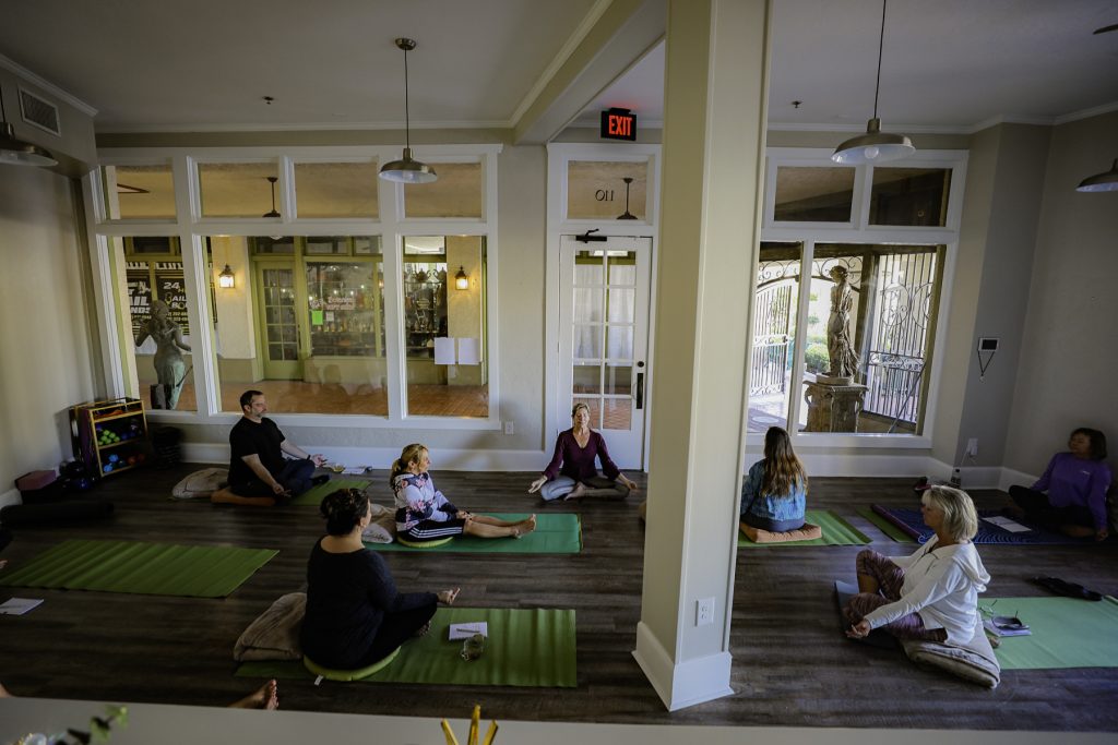 group of people practicing yoga in a studio